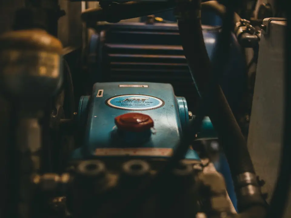 Nahaufnahme eines blauen Industriemotors mit Schläuchen und mechanischen Teilen