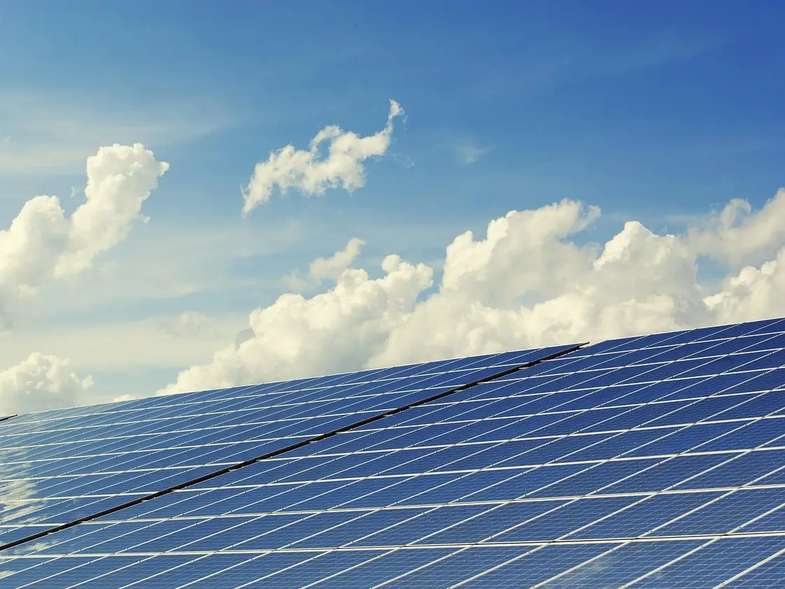 Solarmodule unter blauem Himmel mit lockeren Wolken in der Schrägansicht